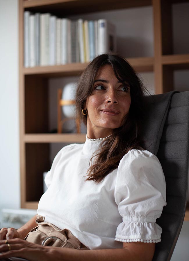 Daphne Maierna smiling in a chair
