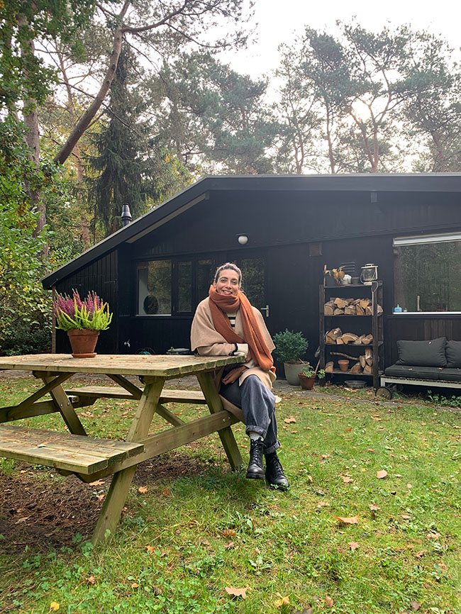 Daphne Maierna sitting at a picnic table in a garden